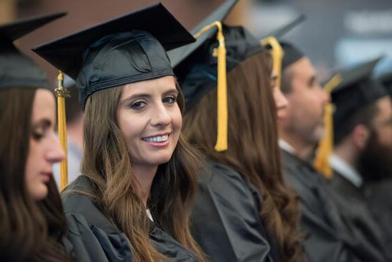 Female student in cap and gown smiing